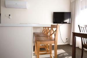 a kitchen with a table and chairs and a tv at Centralpoint Motel in Wagga Wagga