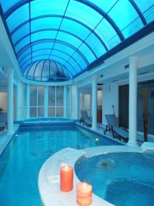Arcadia Suites & Spa في غالاتاس: مسبح كبير بسقف ازرق