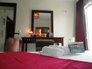 a bedroom with a bed and a table with a mirror at Arcadia Suites & Spa in Galatas