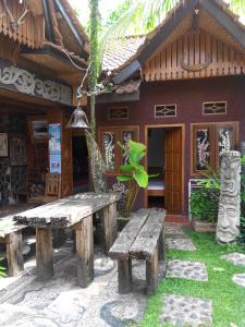 a wooden bench in front of a house at Mini Tiga Homestay in Pangandaran