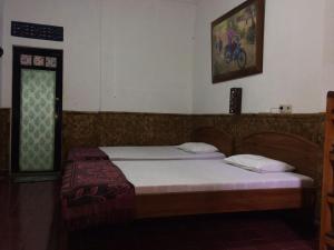 a bedroom with a bed and a window and a bed sidx sidx sidx at Mini Tiga Homestay in Pangandaran