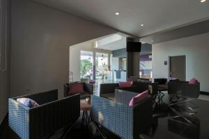 a living room with chairs and a table and a television at RedDoorz near Goa Sunyaragi in Cirebon