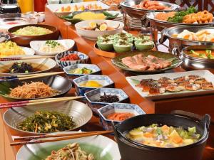 een tafel met veel verschillende gerechten op het eten bij Royal Hotel Odate in Odate