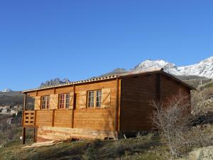 a wooden cabin on a hill with a mountain in the background at Les Chalets De Lozzi in Calacuccia