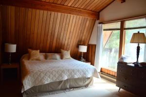 a bedroom with a bed and a large window at Gabriola Central B&B in Gabriola
