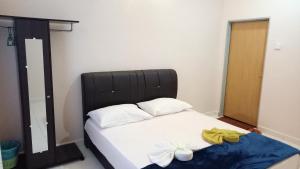 un letto con testiera nera in una stanza di IDUL Sunrise View a Pantai Cenang
