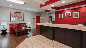 a waiting room with a red wall and a red couch at Best Western Paris Inn in Paris +9 photos