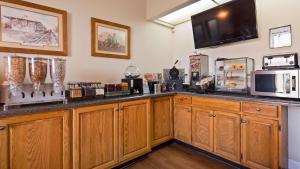 cocina con armarios de madera y encimera en Best Western Wilderness Trail Inn, en Barbourville