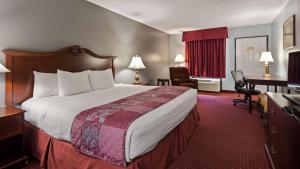 ein Hotelzimmer mit einem großen Bett und einem Schreibtisch in der Unterkunft Best Western Wilderness Trail Inn in Barbourville