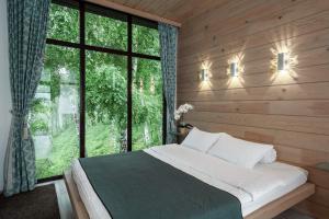 a bedroom with a bed and a large window at Aytau Sporting-Hotel in Chemal