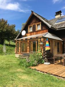eine Blockhütte mit einer Holzterrasse davor in der Unterkunft Haus Katrin in Sankt Marein bei Knittelfeld