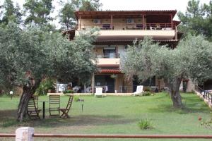 a house with trees in front of it at Bambola Apartments in Nea Moudania