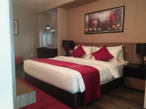 a hotel room with a large bed with red pillows at Urbano Luxury Maritime Suite in George Town
