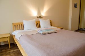 ein Bett mit zwei Kissen auf einem Zimmer in der Unterkunft City Inn Riga Apartment Old Town Home with parking in Riga