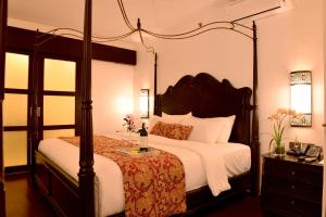 a bedroom with a canopy bed with a white bedspread at Boracay Summer Palace Hotel in Boracay