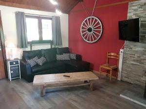 a living room with a black couch and a table at Ardennes in Rendeux