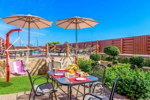 a table and chairs with a playground in the background at Lindos Ruby in Líndos