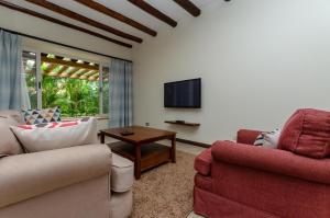 a living room with two chairs and a tv at No.5 Boutique Hotel in Entebbe