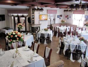a banquet hall with white tables and chairs and flowers at Hotel and Restaurant Complex Lubokray in Pereiaslav-Khmelnytskyi