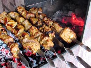 a bunch of food is cooking on a grill at Hotel and Restaurant Complex Lubokray in Pereiaslav-Khmelnytskyi