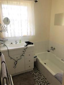 a bathroom with a sink and a bath tub at Admurraya House Bed & Breakfast in Rutherglen