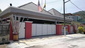 un negozio di fronte con garage rosso e bianco di Weng Kong Homestay a Slim River