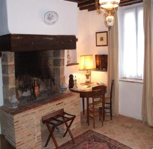 a living room with a fireplace and a table and chairs at Le Moulin d'Hys in La Cropte
