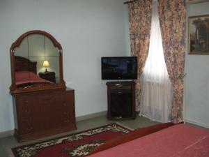 a bedroom with a mirror and a dresser and a tv at Giuseppe Hotel in Kazan