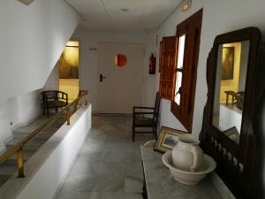 um corredor com escadas e um vaso sobre uma mesa em Hotel Maestre em Córdoba