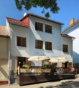 a white building with umbrellas in front of it at Pension Adam in Horní Planá