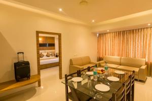 Habitación con mesa de comedor y sala de estar. en Grand Plaza Suites en Kozhikode