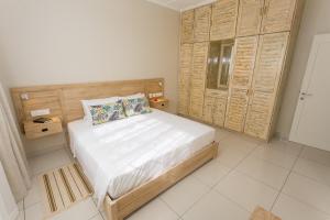 Schlafzimmer mit einem Bett mit einem Kopfteil aus Holz in der Unterkunft Beau Vallon Villa Chalets in Beau Vallon