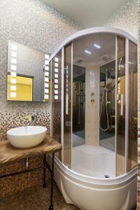 une salle de bain avec un lavabo et un grand miroir dans l'établissement ViP apartment in ♥ of Lviv, à Lviv