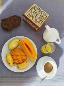 a plate of food with fruit and a cup of coffee at Riverman Hotel in Zanzibar City