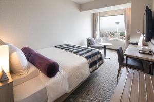 ein Hotelzimmer mit Bett, Schreibtisch und Fenster in der Unterkunft HOTEL MYSTAYS Hakodate Goryokaku in Hakodate
