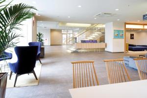a lobby with chairs and tables in a building at HOTEL MYSTAYS Hakodate Goryokaku in Hakodate