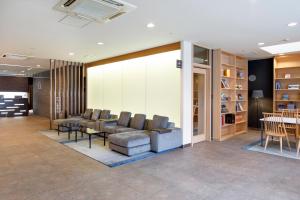 a lobby with a couch and chairs and a table at HOTEL MYSTAYS Hakodate Goryokaku in Hakodate