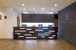 eine Lobby mit einer Bar und zwei Barhockern davor in der Unterkunft HOTEL MYSTAYS Hakodate Goryokaku in Hakodate
