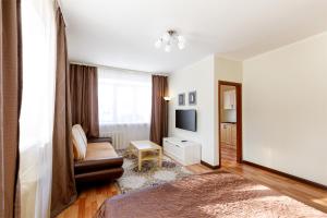 a living room with a couch and a television at Апартаменты Авион Комфорт in Kemerovo