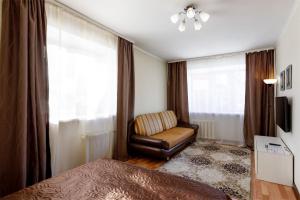 a bedroom with a chair and a window at Апартаменты Авион Комфорт in Kemerovo