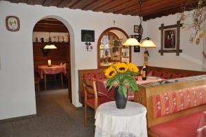 un restaurante con un jarrón de flores sobre una mesa en Hotel Maroi, en Wald am Arlberg