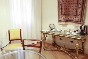 ボローニャにあるCasa Isolani Piazza Maggiore 1.0のテーブル、椅子、ガラステーブルが備わる客室です。