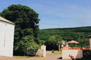 a building with a gate and a mountain in the background at Taff Trail Bunkhouse in Merthyr Tydfil