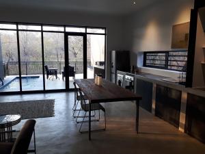 eine Küche mit einem Holztisch und einem großen Fenster in der Unterkunft Ochre House in Marloth Park