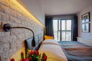 een slaapkamer met een bakstenen muur en een bed met bloemen bij Hotel Czarna Róża in Toruń