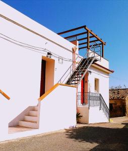 a white house with a staircase on the side of it at Agriturismo Aiolia - Panorama Eolie in Mongiove