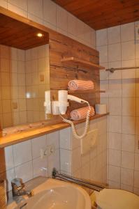 een badkamer met een wastafel, een toilet en een spiegel bij Hotel Maroi in Wald am Arlberg