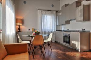 RELAIS VAL D'ORCIA في بينزا: مطبخ مع طاولة وكراسي في غرفة