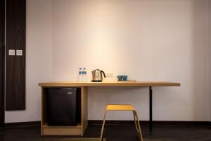 une table en bois avec une chaise et une cafetière. dans l'établissement Xianghe Hotel, à Mingjian