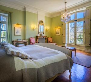 a bedroom with a large bed and a chandelier at Chateau de Tourreau in Sarrians